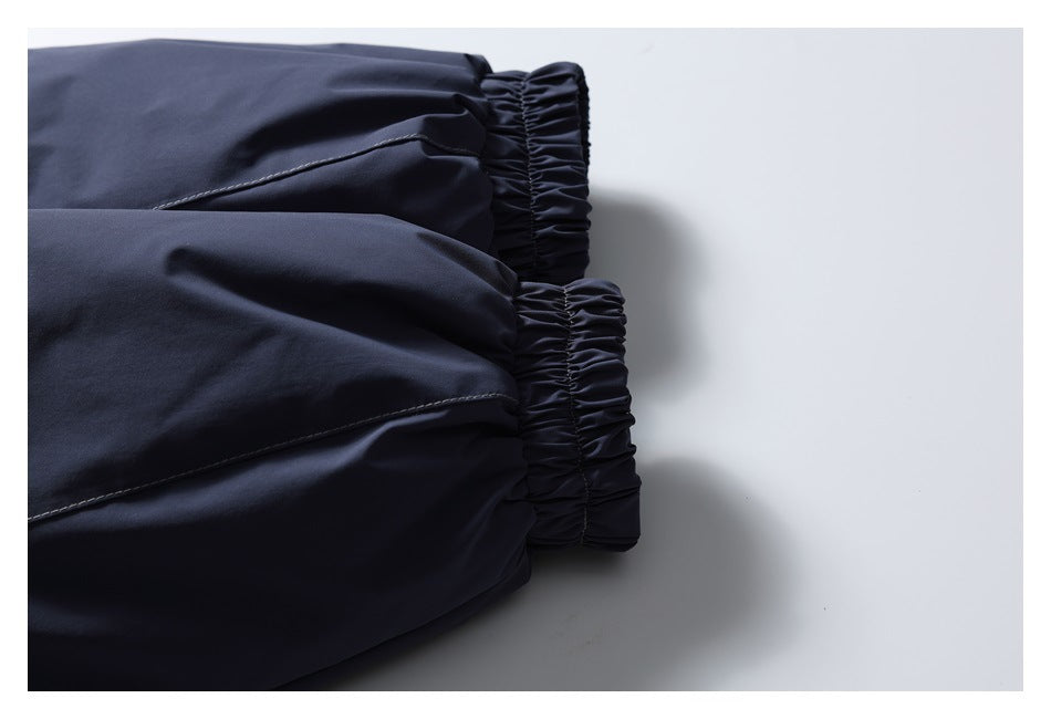 Close-up of two navy jacket cuffs with gathered elastic and visible seam stitching.