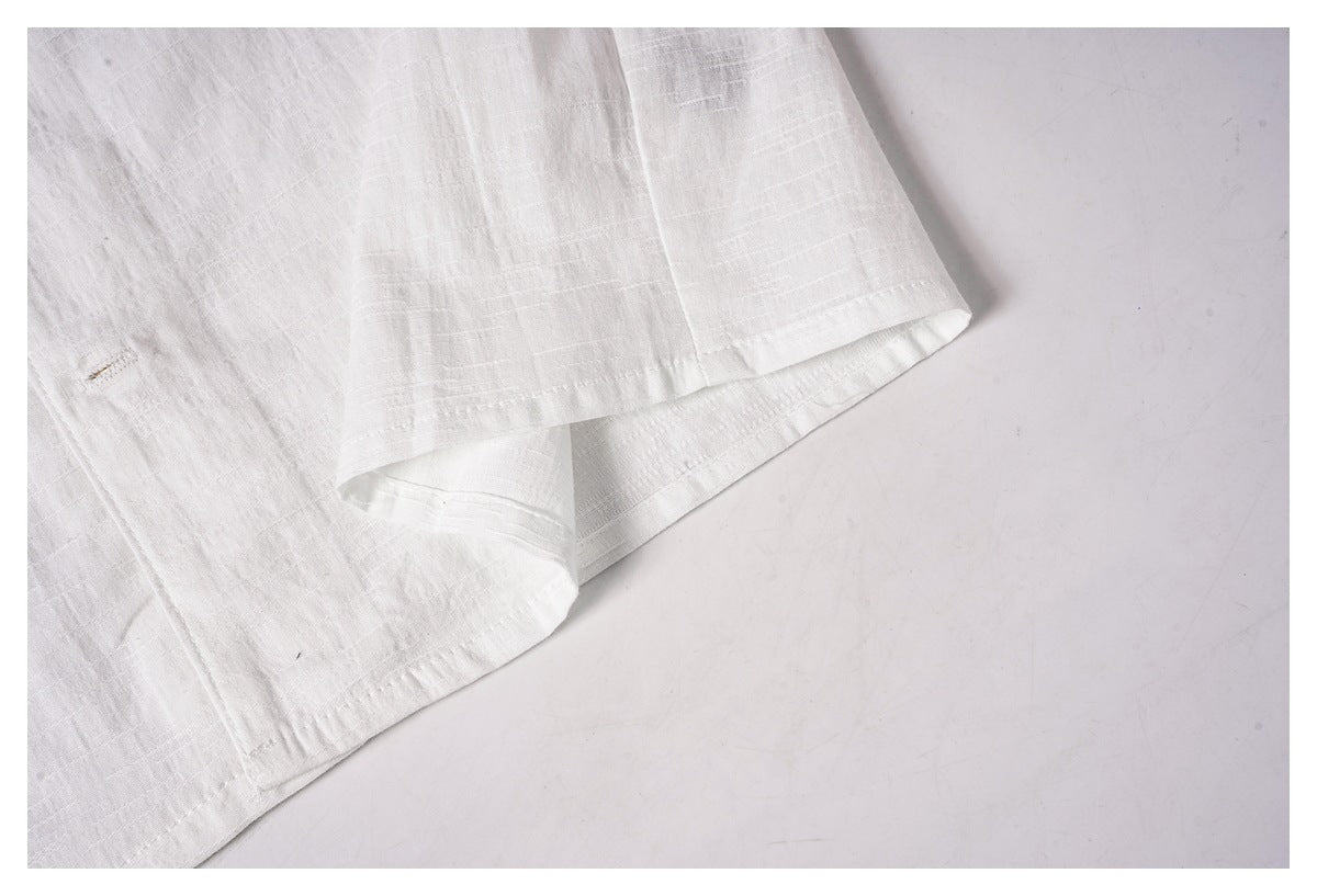 Close-up of the white shirt's stitched lower hem and overlapping fabric edge.