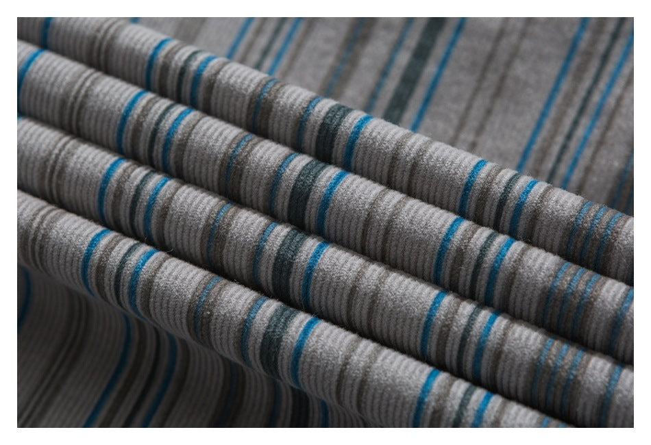 Close-up of gray striped garment fabric arranged in soft folds, with blue and charcoal lines.