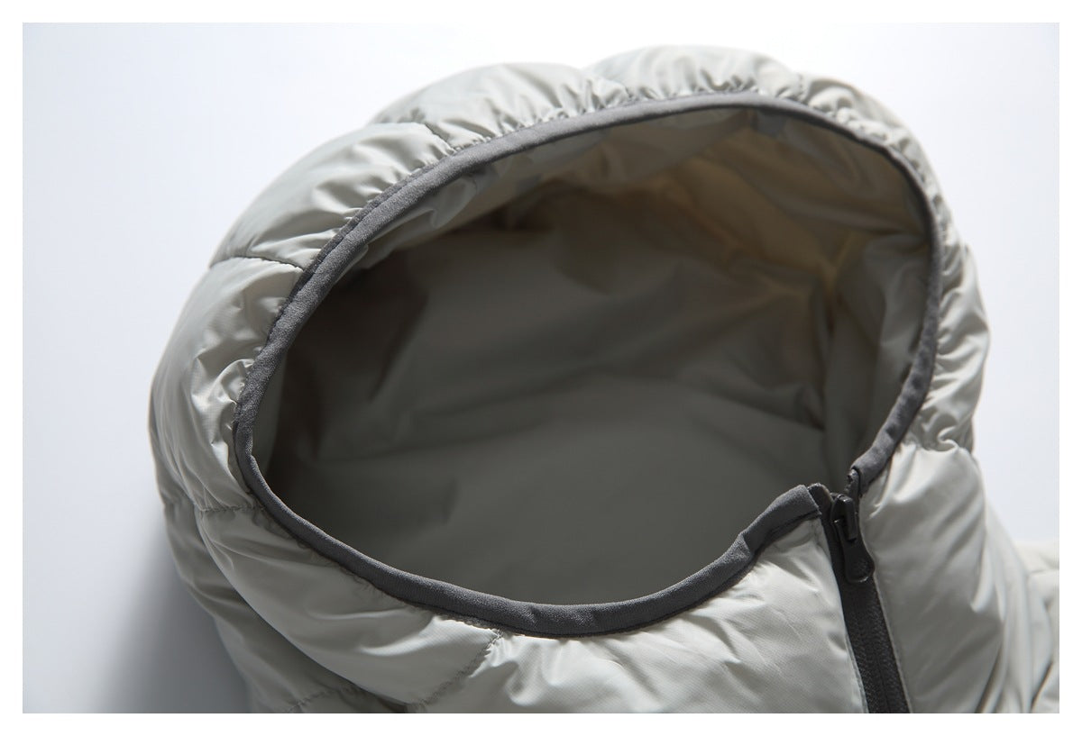 Close-up of a light gray quilted jacket hood with dark gray edging and a zipper.