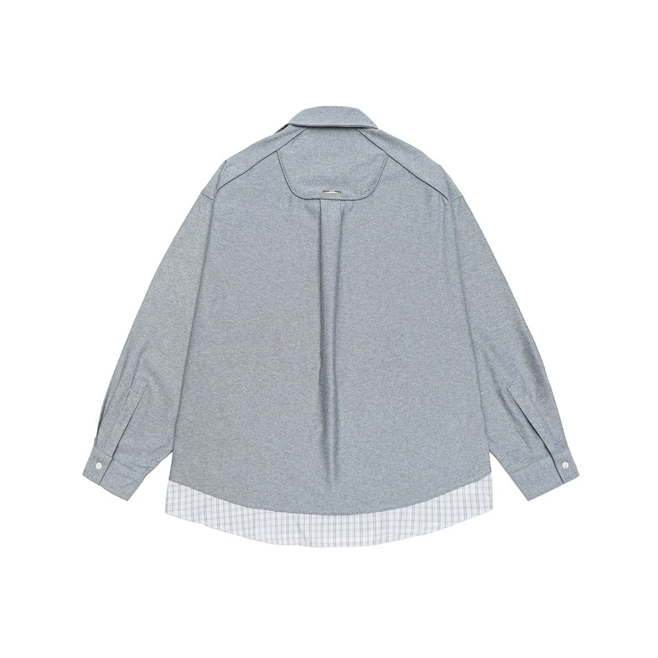 Back view of a gray shirt with a curved yoke and plaid fabric along the hem.