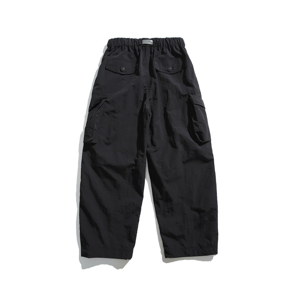 Black cargo trousers shown from the back, with an elastic waistband, two buttoned rear pockets, and side cargo pockets.
