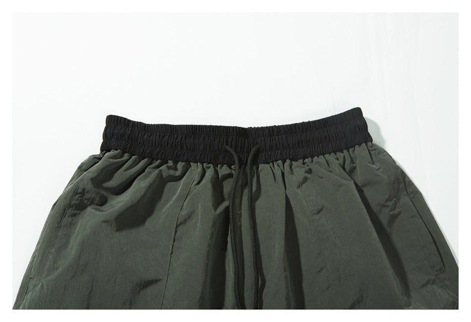Close-up of the shorts' front, showing the black elastic waistband and dangling drawcords.