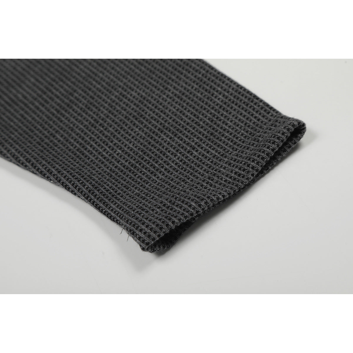 Close-up of the charcoal waffle-knit shirt sleeve and finished cuff.