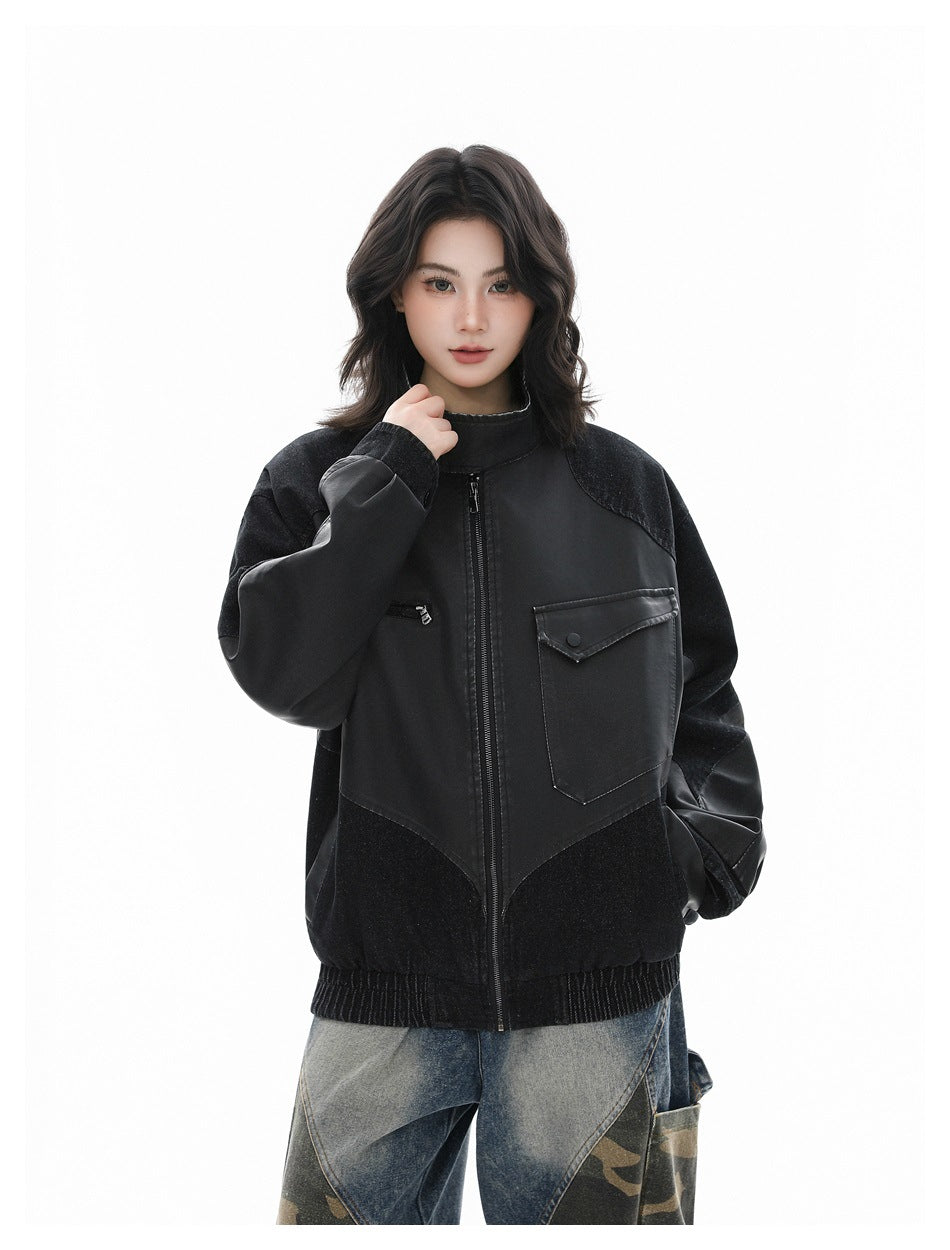 Model wearing the black patchwork zip jacket with one hand at the collar and the other in a pocket, front view