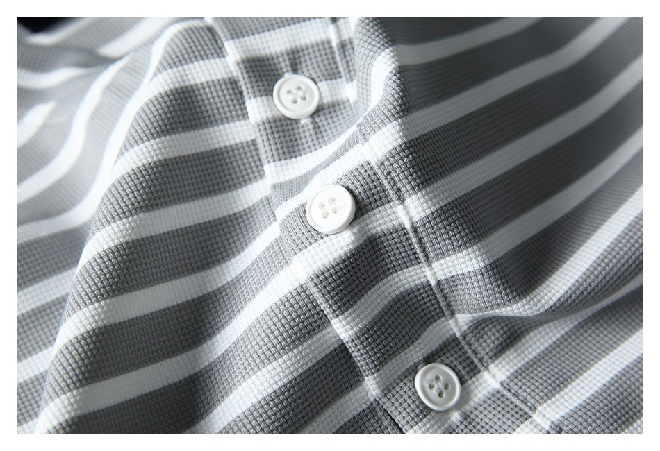 Close-up of a gray-and-white striped placket with three white buttons and textured fabric.
