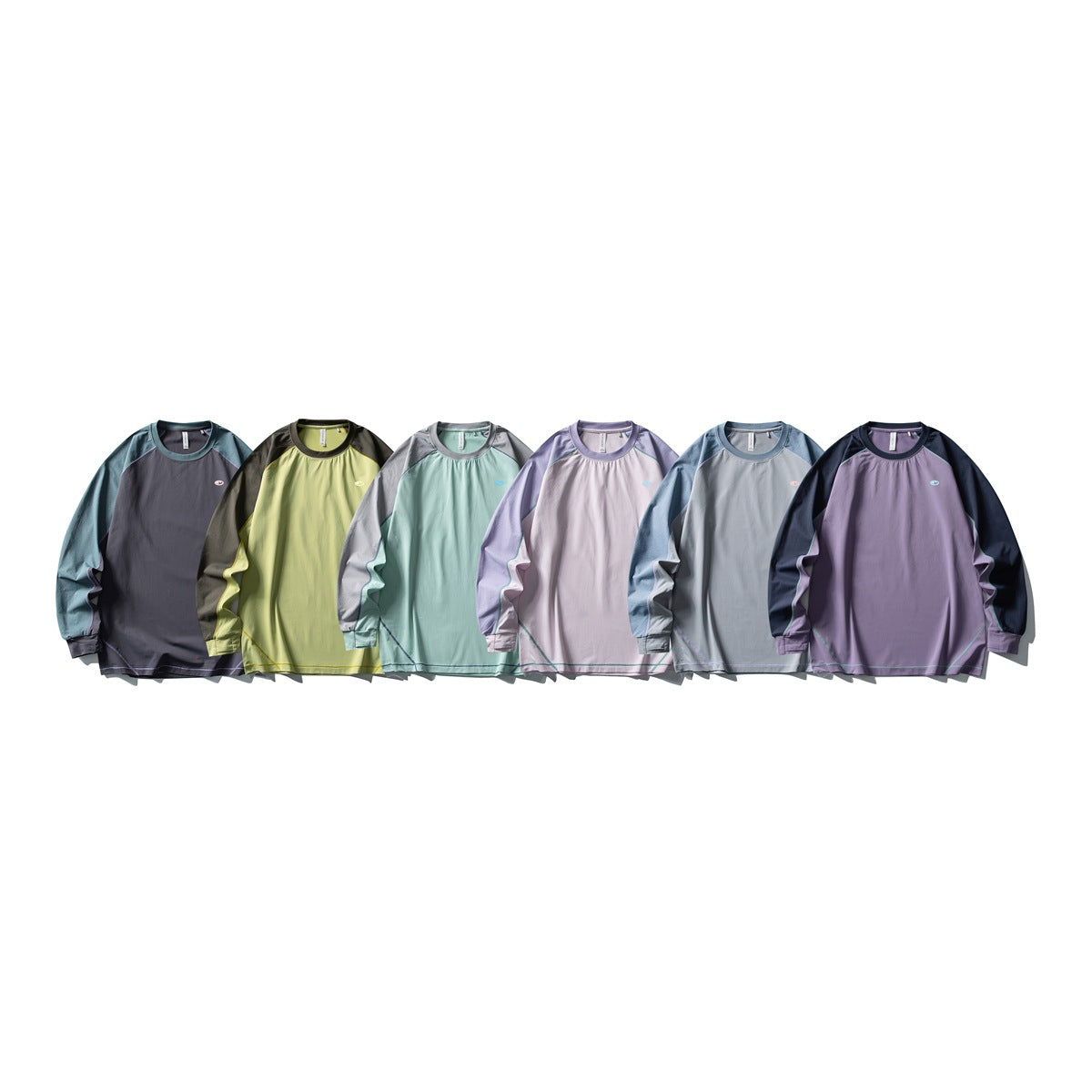 Six long-sleeve color-block tops displayed together in charcoal, yellow, aqua, lavender, gray-blue, and purple.