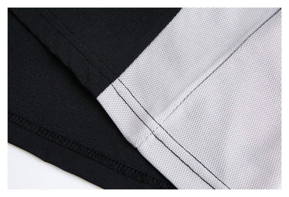 Close-up of black and light gray shirt panels with visible seam and hem stitching.