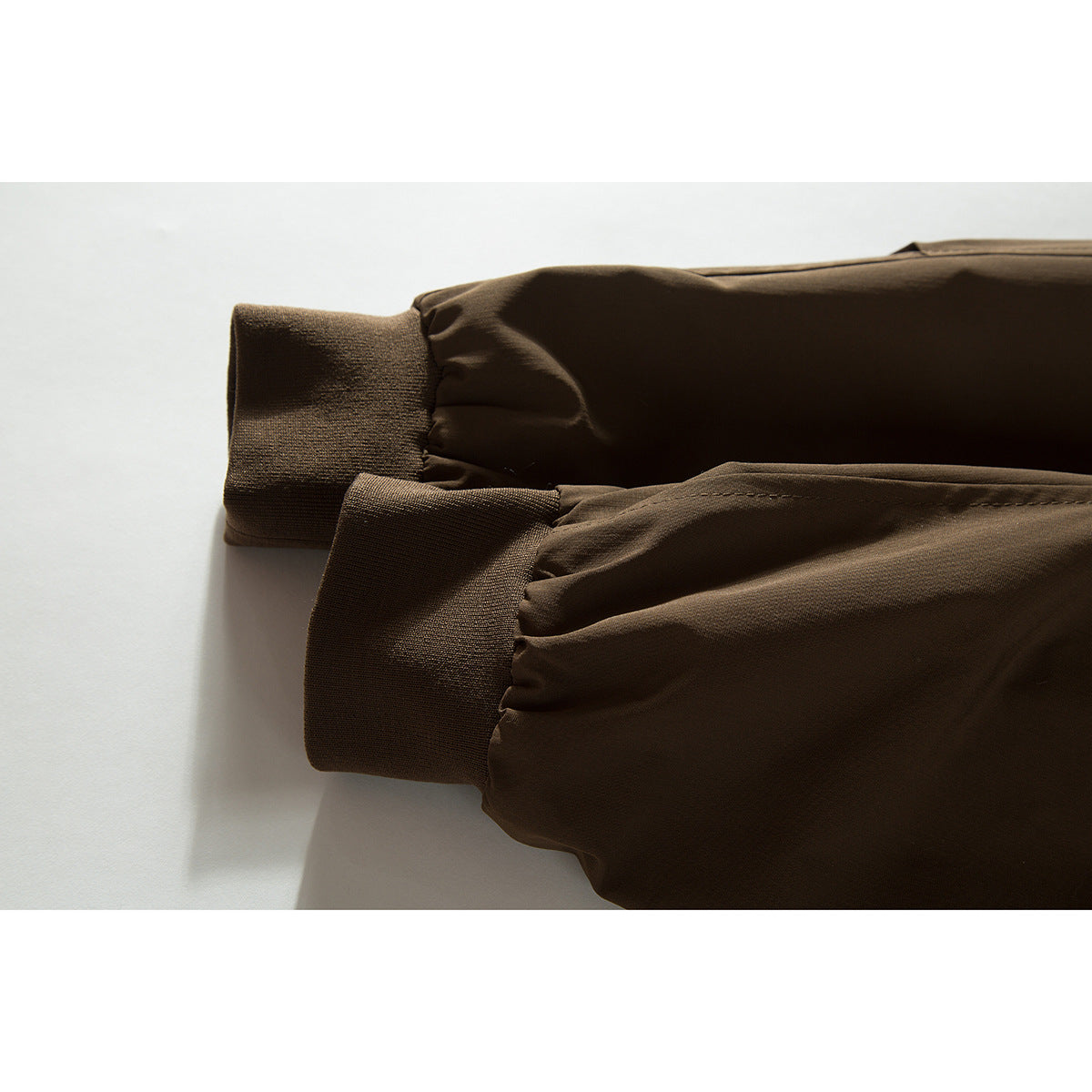 Close-up of the dark brown jacket's gathered sleeve ends and ribbed cuffs.