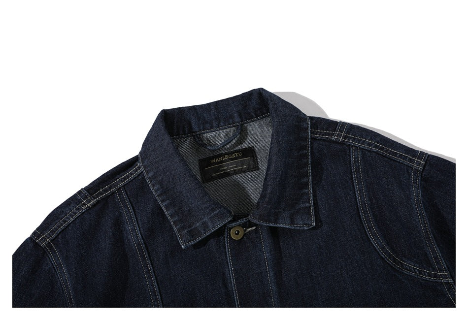 Close-up of the dark denim jacket's collar, contrast stitching, top button, and sewn-in neck label.