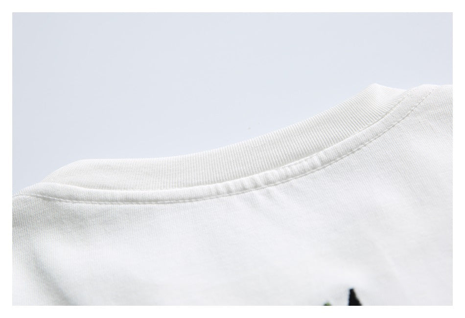 Close-up of the ribbed neckline and shoulder seam on a white shirt.