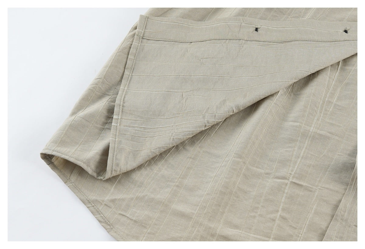 Close-up of beige shirt fabric folded back to show stitched construction and the inside surface.
