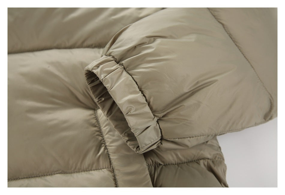 Close-up of a taupe puffer jacket sleeve cuff with gathered elastic and stitched quilting.
