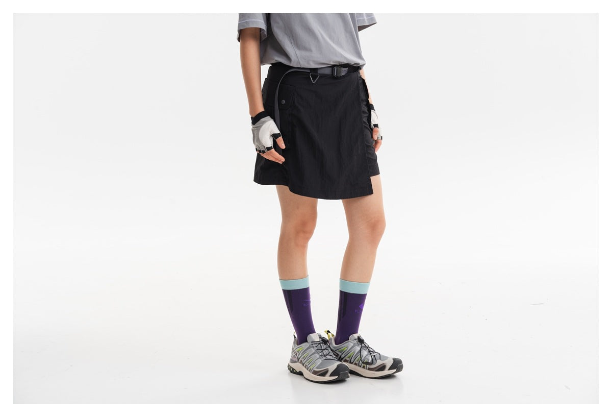 Cropped model wearing a black short skirt with a belted waist, styled with a gray T-shirt and purple socks.