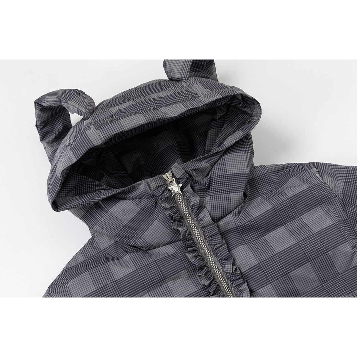 Close-up of a gray-and-black plaid hooded jacket with a ruffle-trimmed zipper and decorative star-shaped pull.