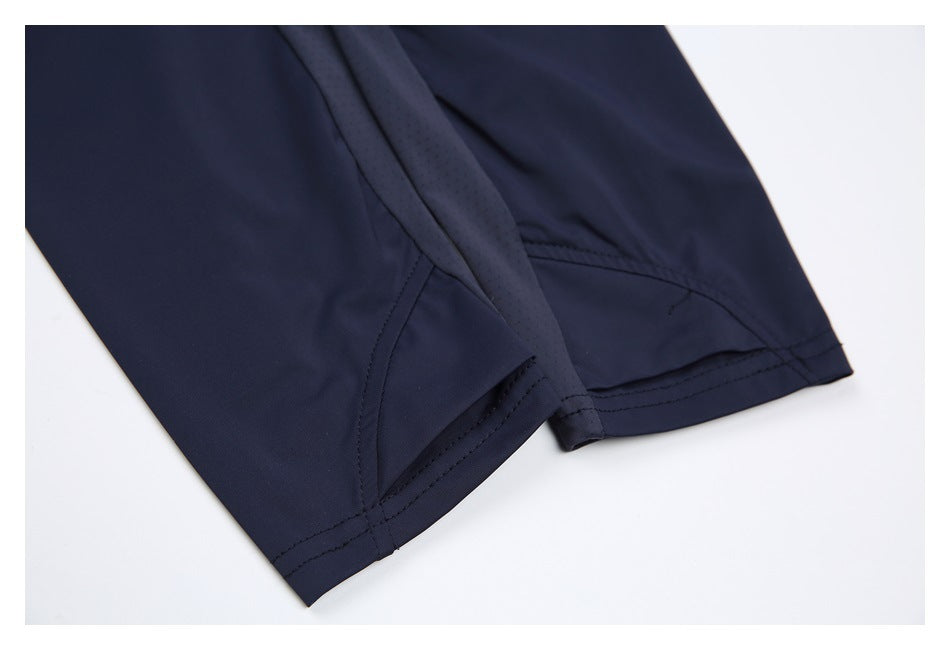 Close-up of dark navy garment hems with double stitching and a perforated fabric panel.
