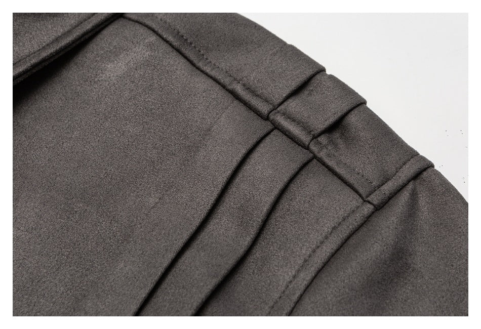 Close-up of the gray jacket’s shoulder with layered stitched tabs and seam details.