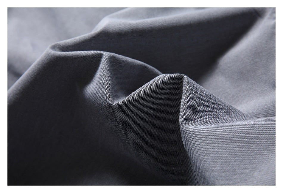 Close-up showing the fine woven texture and folds of gray shirt fabric.
