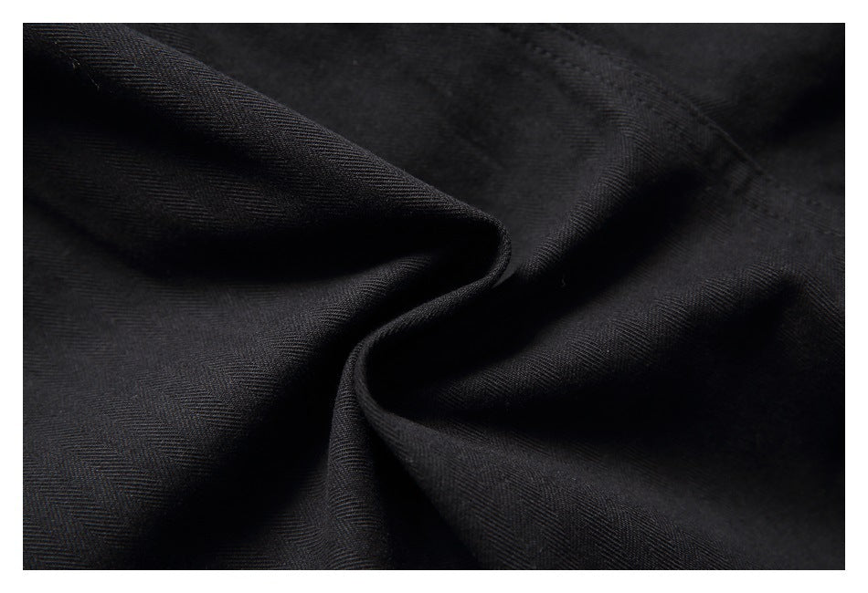 Close-up of black fabric gathered into folds, showing its subtle woven texture.