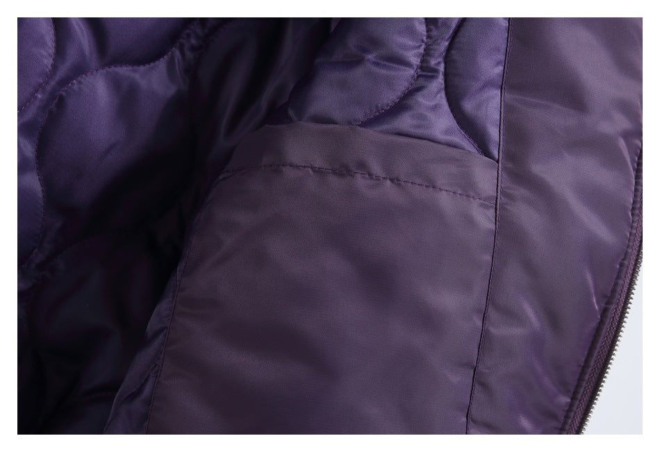 Interior close-up of the dark purple jacket, showing a pocket, lining, and zipper edge.