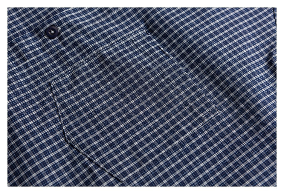 Close-up of the blue plaid shirt's button and chest pocket.