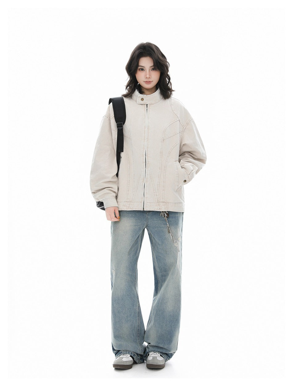 Full-length view of a model in an oversized light khaki zip jacket, faded wide-leg jeans and gray sneakers