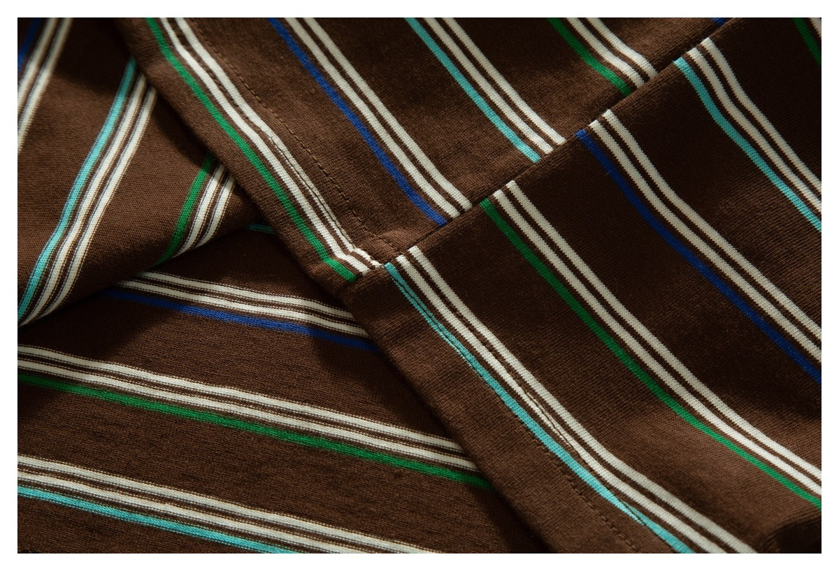 Close-up of folded brown garment fabric with multicolored stripes and visible seam stitching.