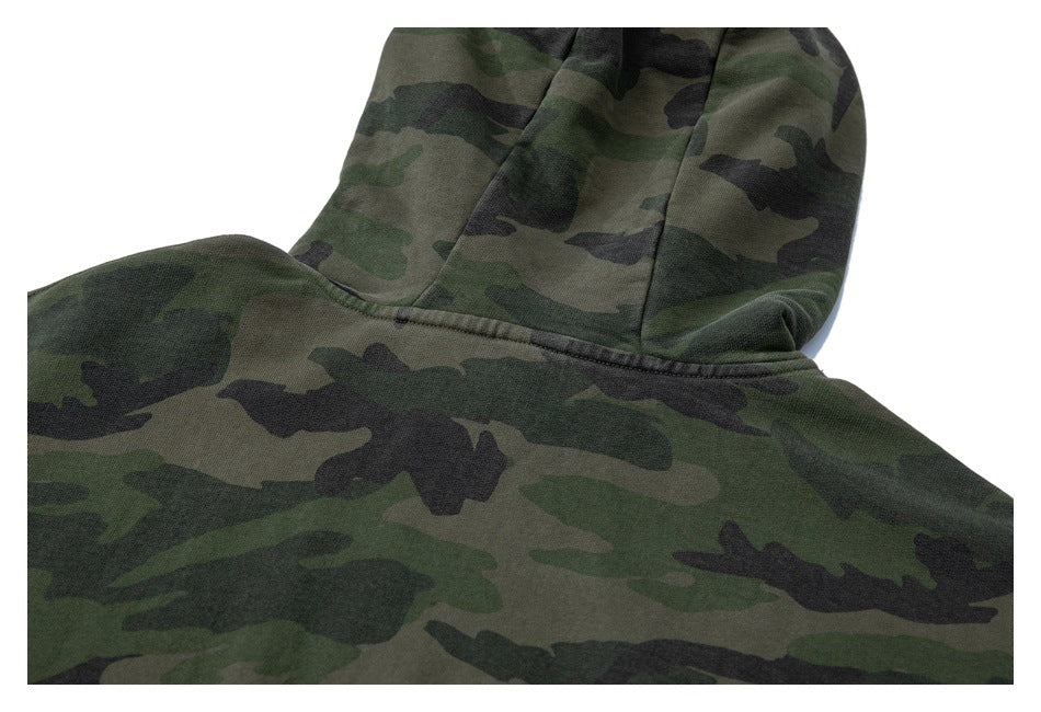 Close-up of the hood and back shoulder seam on a green camouflage hoodie.