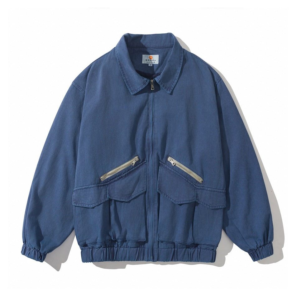 Blue washed collared zip jacket, flat front view, with two large flap pockets, diagonal zips and elastic cuffs and hem