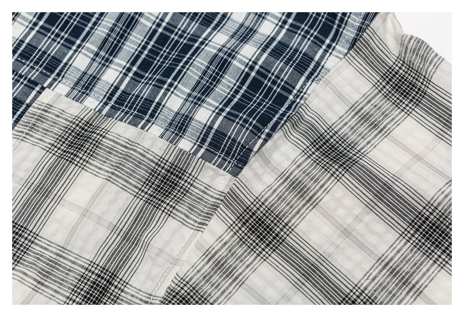 Close-up of a seam joining navy-and-white plaid fabric to gray-and-black plaid fabric.