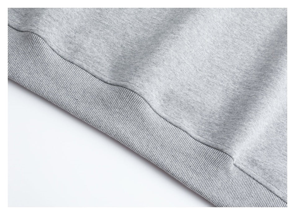 Close-up of the light gray vest's ribbed bottom hem and seam.