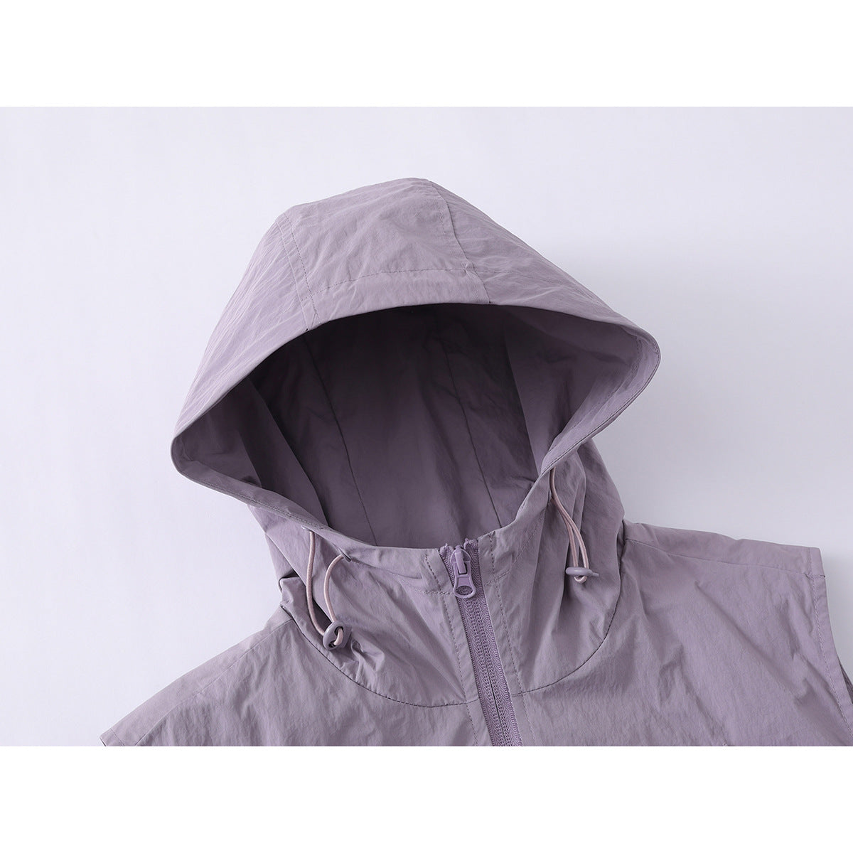 Close-up of a lavender hooded vest showing the lined hood, drawcords and front zipper.