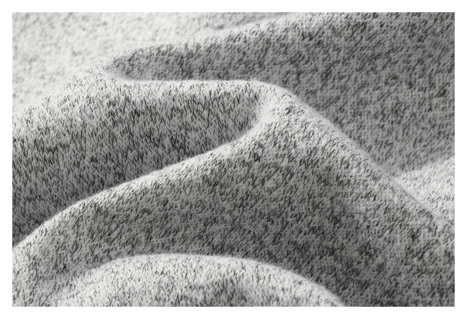 Macro detail of the gray marled knit fabric draped in soft folds.