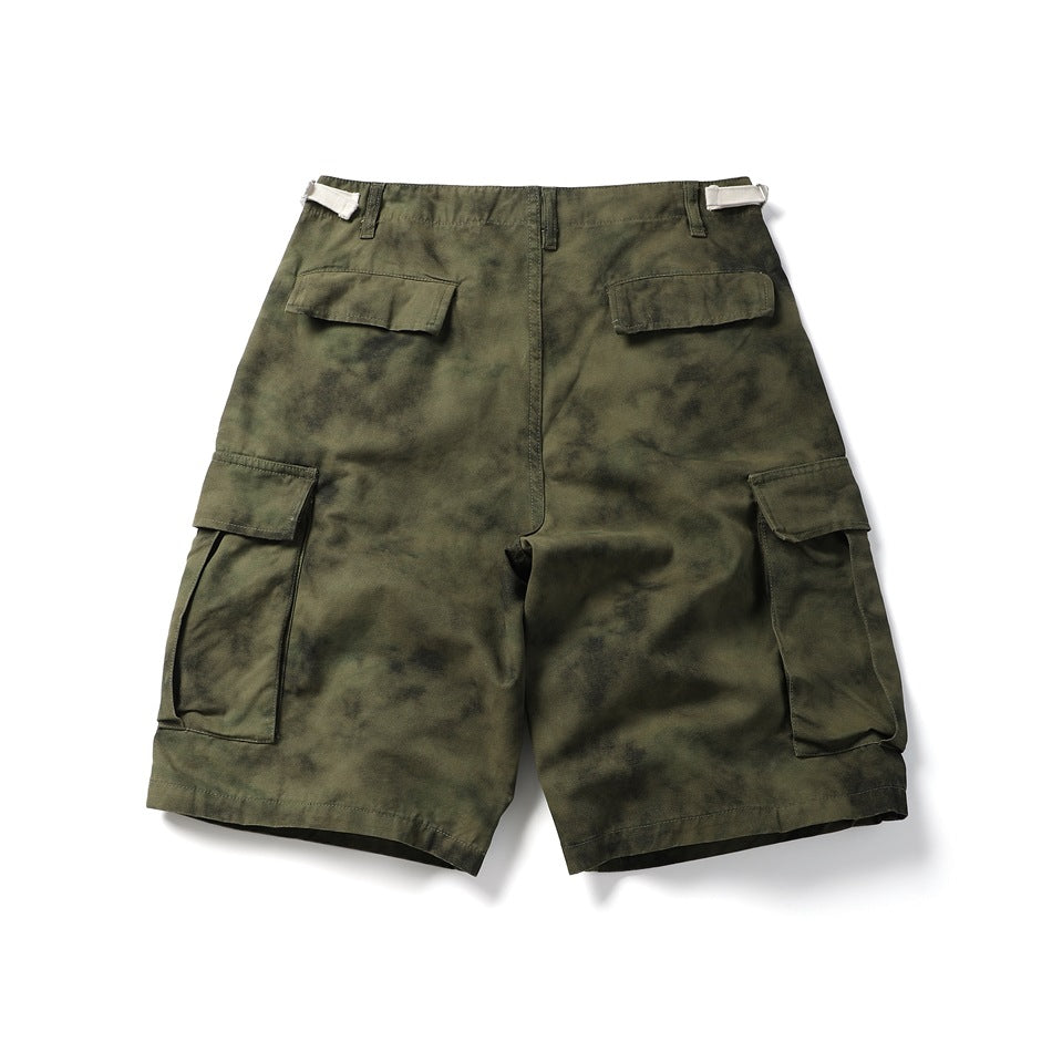 Full rear view of olive-green mottled cargo shorts with flap pockets and adjustable waist tabs.