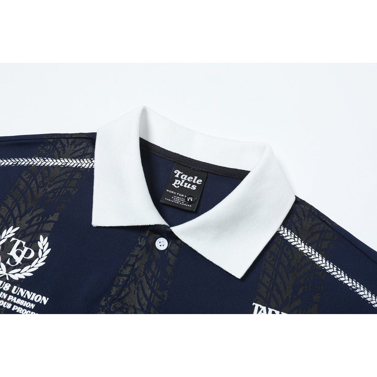Close-up of a navy polo shirt with a white collar, button, dark patterned panels, and white printed graphics.