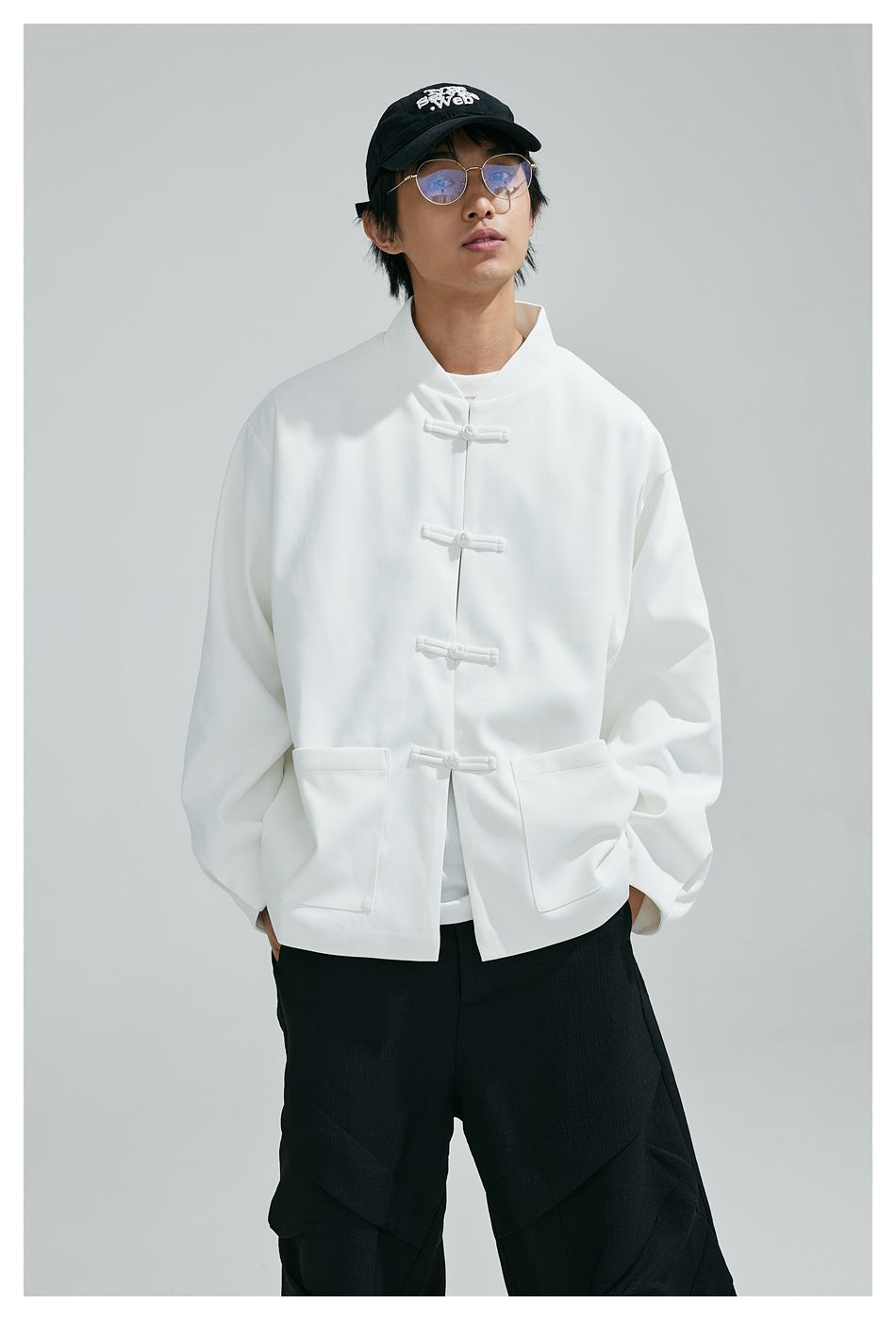 Front view of a model wearing a white frog-button jacket with two large front pockets.