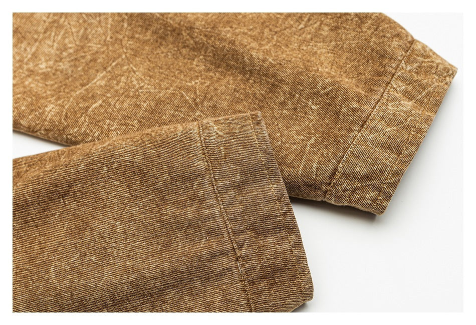 Close-up of brown mottled fabric with stitched folded hems and a wide cuff.