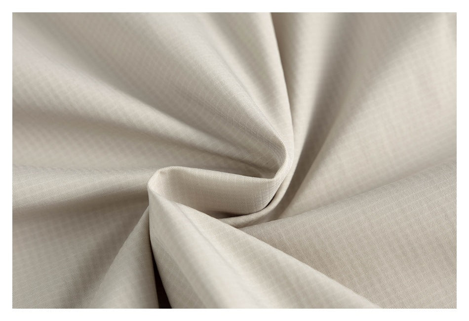 Close-up of the light beige jacket fabric gathered into soft folds.