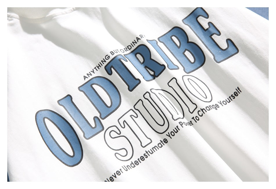 Close-up of a white T-shirt showing its large blue-and-black printed lettering.