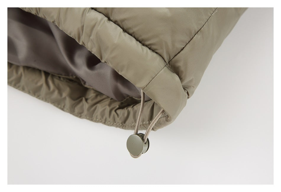 Close-up of the puffer jacket’s hem drawcord and round adjustment toggle.