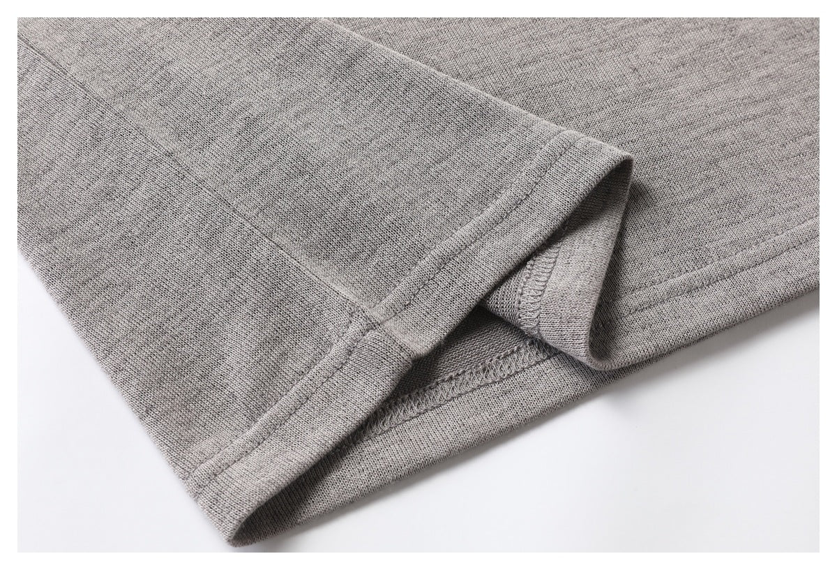 Close-up of a heather gray garment hem and seam stitching, with the edge turned back.