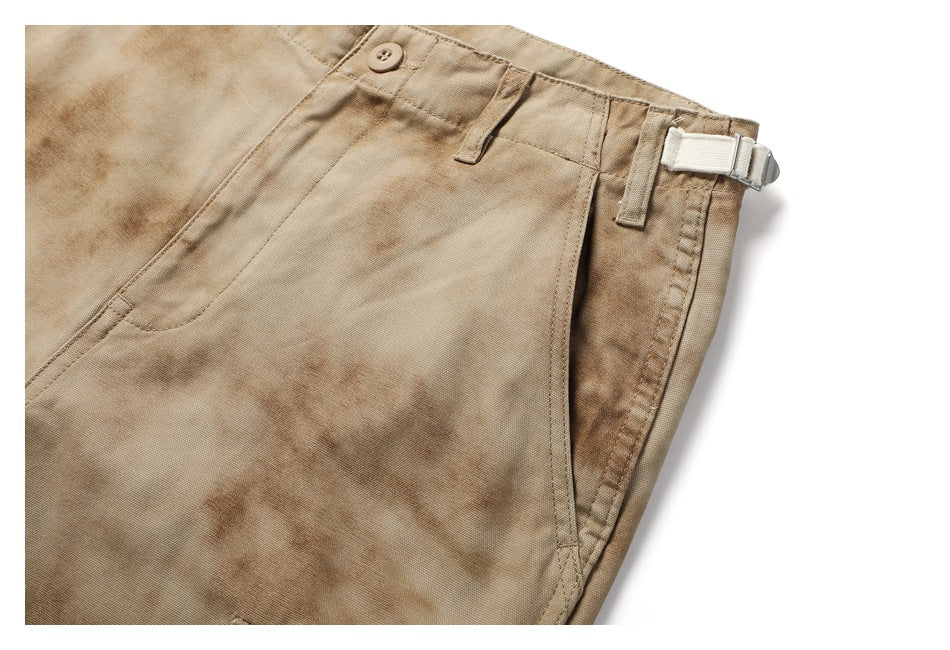 Close-up of the tan mottled pants’ waistband, side adjuster, belt loops and slanted pocket.