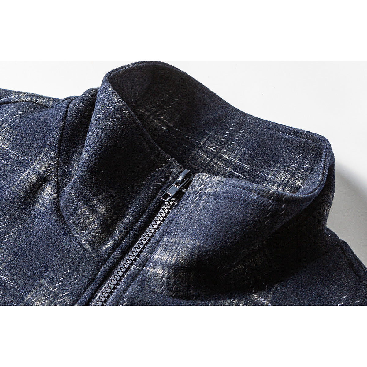 Close-up of a dark navy plaid jacket's stand collar and front zipper.