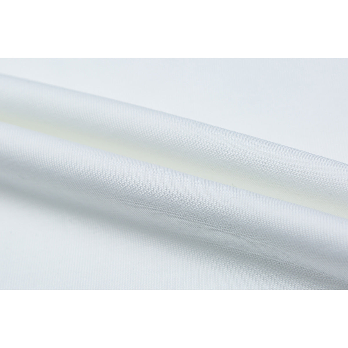 Close-up of white T-shirt fabric arranged in soft folds.