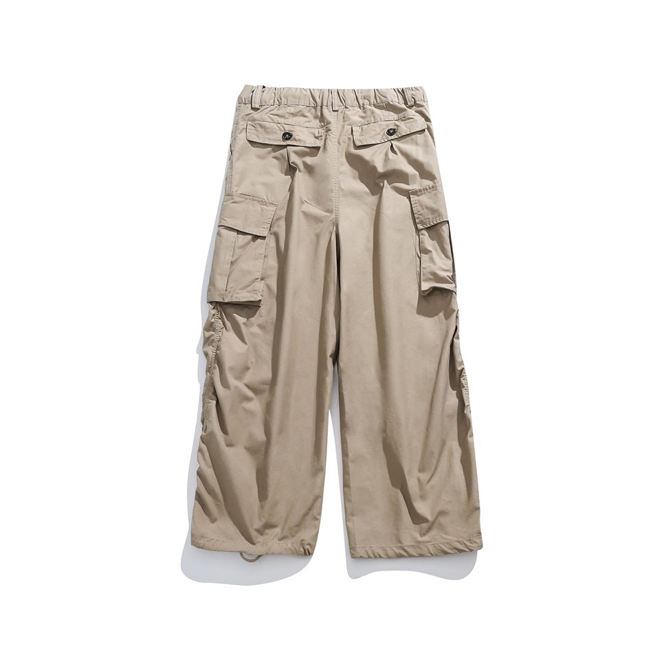 Back view of beige cargo pants with button-flap rear pockets, large side pockets, and gathered hems.