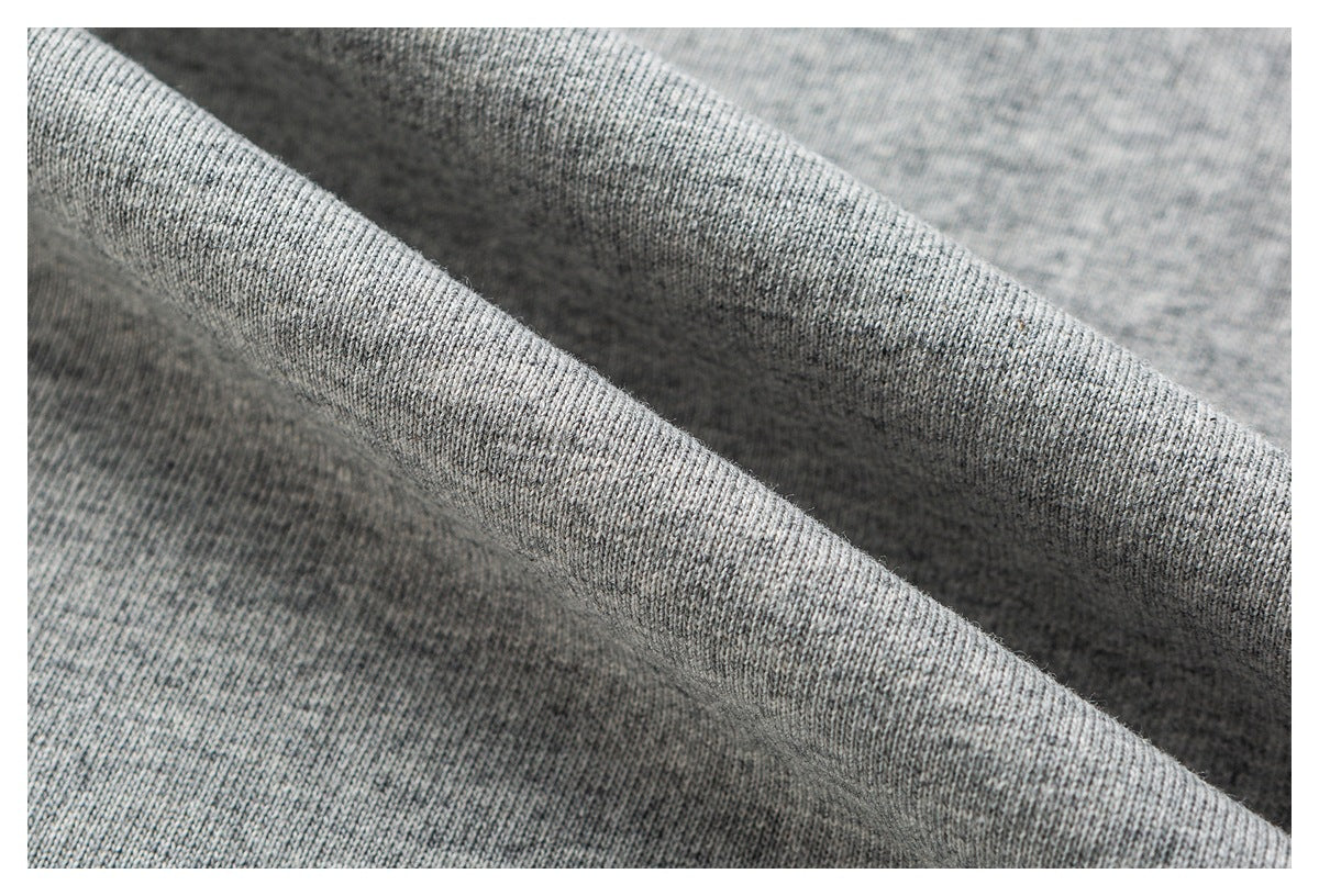 Macro view of folded heather-gray knit fabric showing its textured surface.