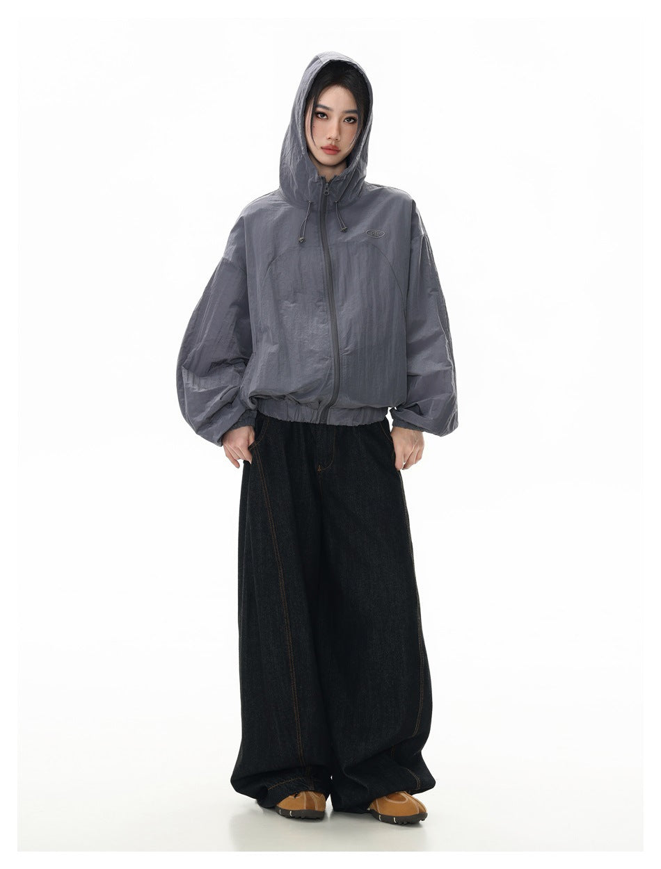 Full-length model wearing a slate-gray hooded zip jacket with the hood up, shown from the front.