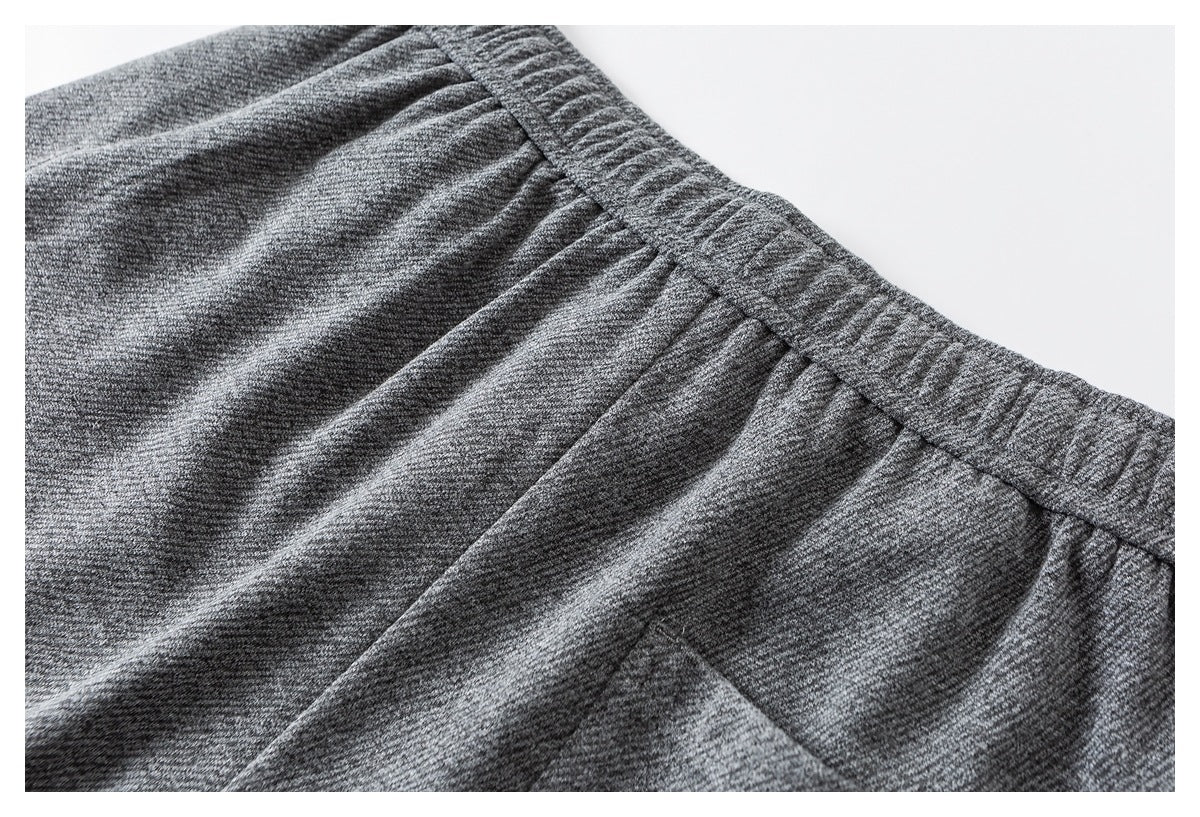 Close-up of heather gray joggers showing the gathered elastic waistband and pocket edge.