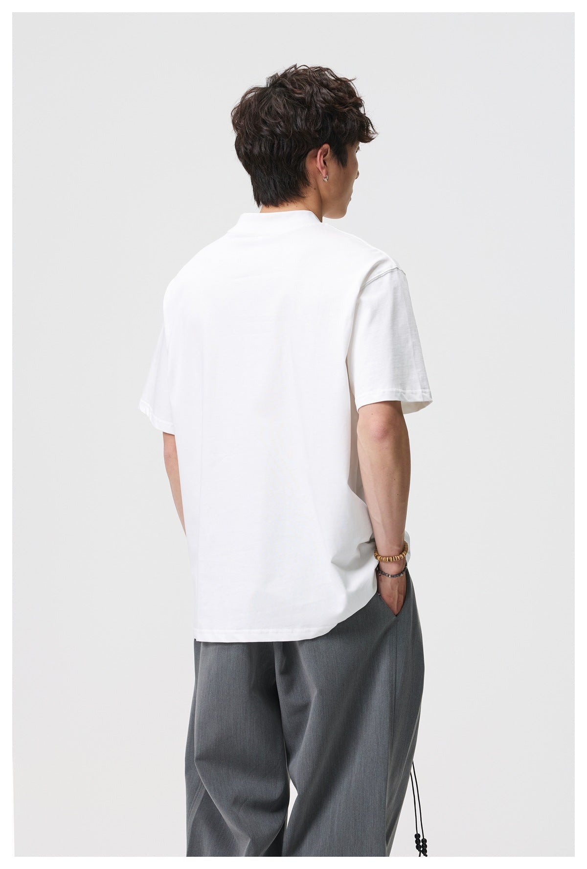 Rear view of a model wearing a plain white short-sleeve T-shirt.