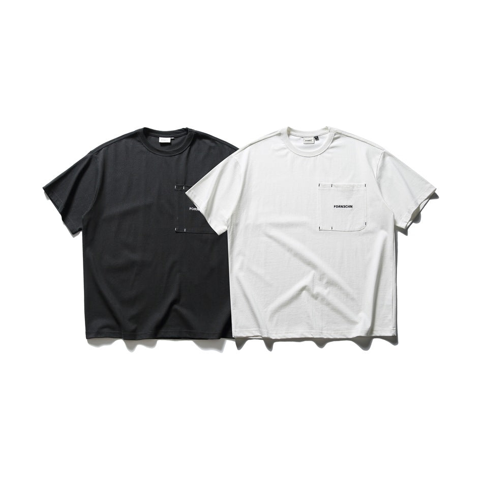 Two oversized T-shirts shown flat: one black and one white, each with a stitched chest pocket and black text.